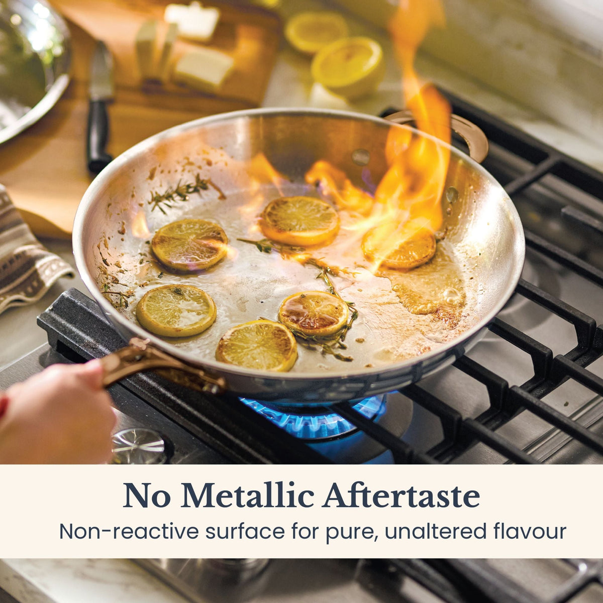 Lemon slices and thyme flambéing in an Anolon EverLast stainless steel skillet on a gas burner, showing its non-reactive cooking surface